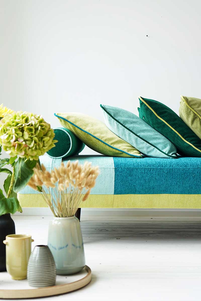 Couch mit grünen, blauen und gelben Kissen, Firma Höpke, Pura FR